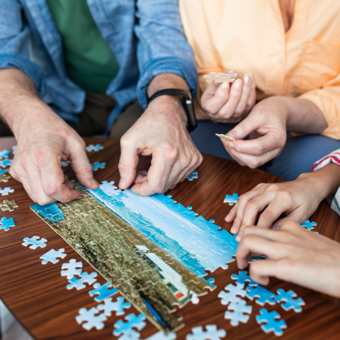 Three people working on a jigsaw puzzle